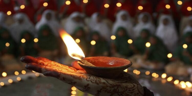 A Muslim schoolgirl holds an oil lamp ahead of the celebrations for Hindu festival of Diwali at a school in the western Indian city of Ahmedabad October 25, 2008. Lamps are traditionally used to decorate homes during Diwali, the annual Hindu festival of lights. The festival will be celebrated across the country on October 28. REUTERS/Amit Dave (INDIA)